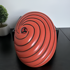 Máscara naranja de Tobi en espiral sobre una mesa